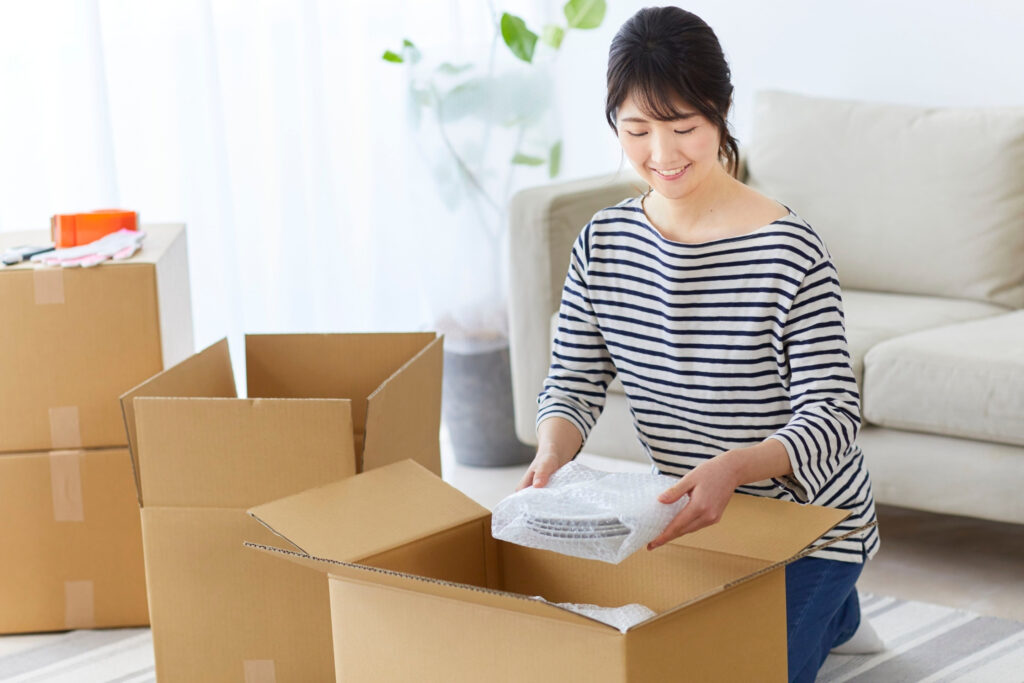 woman decluttering and organising items into boxes